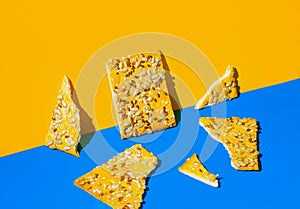 Creative composition made of crunchy cereal cookies on bright blue and orange background. Healthy dessert concept