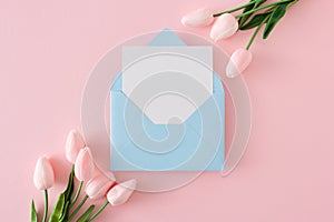Creative composition made of open envelope with white card and spring flowers