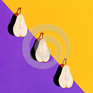 Creative composition made of raw sliced pear on bright violet and orange geometric background with shadow. Minimal style. Healthy