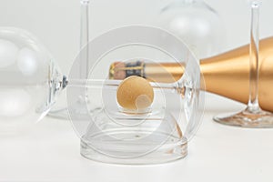 Creative composition with marzipan dessert, glass goblets and a golden bottle of champagne