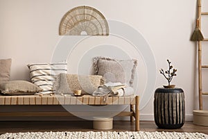 Creative composition of meditation living room interior with mock up poster frame, beige carpet, colorful pillow, coffee table and