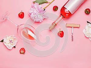 Creative composition with rose wine and delicious strawberries on the pink background