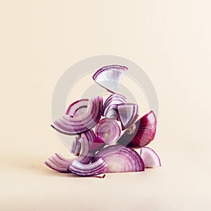 Creative composition of sliced red onion on earthy beige background. Equilibrium floating food balance.