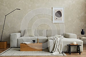 Creative composition of stylish japandi living room with mock up poster frame, grey sofa, wooden cubes, design vases and small. photo