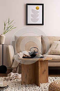 Creative composition of stylish living room with beige sofa, pillow, wooden coffee table, mock up poster frame, black tea pot,