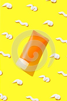 Creative composition with sunscreen lotion on yellow background. Body care beauty treatment concept