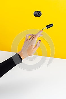 Creative composition with woman`s hands and flying nail varnish