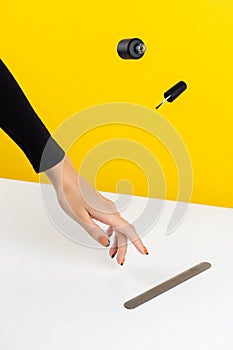 Creative composition with woman`s hands and flying nail varnish