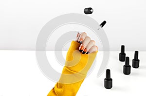 Creative composition with woman`s hands and flying nail varnish