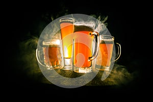 Creative concept. Beer glasses on wooden table at dark toned foggy background