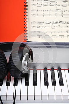 Creative concept of a digital piano keys with big black leather headphones