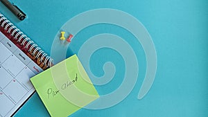 Plan Ahead Concept with Calendar, Sticky Note, and Push Pins on Blue Background