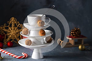 Creative concept with white dishes Christmas tree shape pyramid with cup of tea on top decorated with sweet chocolate truffles on