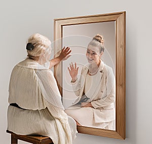 Creative conceptual collage. Tender image of senior woman looking in mirror and smiling to her young self reflection