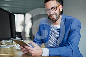 Creative confidence. Portrait of a young businessman working on a digital tablet in an office.