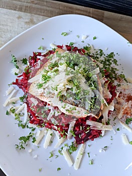 Creative cuisine - fresh beetroot risotto served with pan friend salmon fillet and parmesan crust