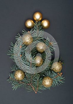 Creative decoration concept with Christmas tree branches and gold baubles