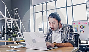 Creative designer feel sleepy while working hard with laptop at modern office.workplace lifesyle concept photo