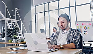 Creative designer feel sleepy while working hard with laptop at modern office.workplace lifesyle concept