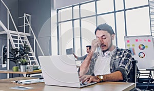 Creative designer get stress while working with laptop at modern office.workplace lifesyle concept photo