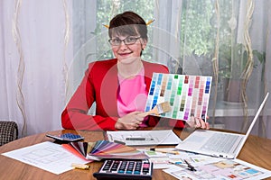 Creative designer with pencils in hair showing colour palette