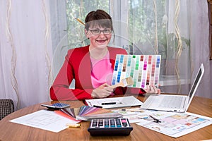 Creative designer with pencils in hair showing colour palette