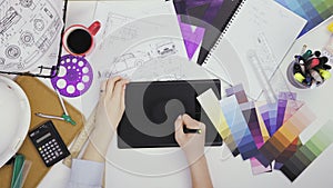 Creative designer using graphics tablet while working at her table