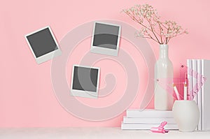 Creative designers workplace - three blank polaroid on wall and white office stationery in pastel pink interior.