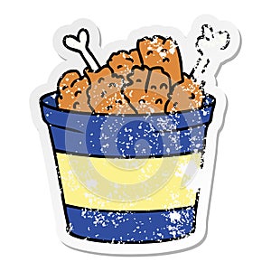 A creative distressed sticker cartoon doodle bucket of fried chicken