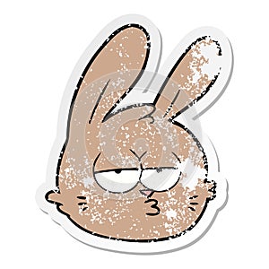 A creative distressed sticker of a cartoon jaded rabbit face