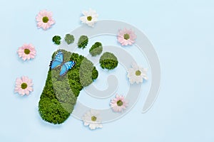 Creative eco, environmental care, earth day concept. Barefoot footprint made of natural green moss, flowers and