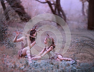 Creative fabulous family shooting, faun mom plays lullaby on flute for her child, fairytale characters deer in long photo
