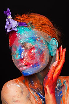 Creative fantastic makeup using colorful paints on the model