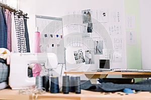 Creative fashion designer desk or workplace with sewing equipment, fabrics, templates, modern stylist inspirational