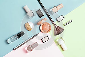 Creative flat lay of fashion bright nail polishes and decorative cosmetic on a colorful background. Minimal style. Copy