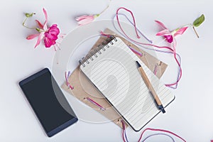 Creative flat lay photo of workspace desk with smartphone, coffee, pencil, flowers with copy space background. Flat lay