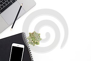 Creative flat lay photo of workspace desk. Top view office desk with laptop, phone, pencil, notebook and plant on white color