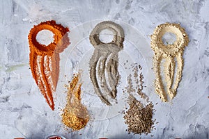 Creative food art concept with abstract figures made of ground spicies, top view, close-up.