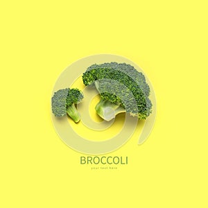 Creative food concept. Fresh raw green broccoli on yellow background. Healthy vegetables, diet vegan organic food, vitamins. Flat