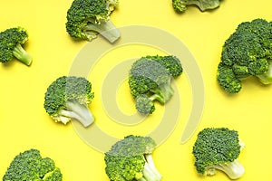 Creative food concept. Fresh raw green broccoli on yellow background. Healthy vegetables, diet vegan organic food, vitamins. Flat