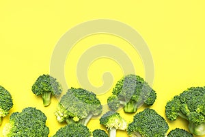 Creative food concept. Fresh raw green broccoli on yellow background. Healthy vegetables, diet vegan organic food, vitamins. Flat