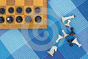Creative foreshortening from above chess concept with wooden desk with black and white figures on game space and lay near on