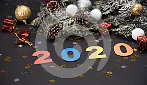 Creative 2020 frame made of Christmas fir branches on white wooden background with red decoration, pine cones. Xmas and New Year.