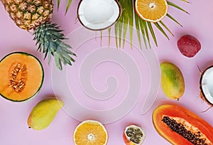 Creative frame with tropic fruits on the pink background