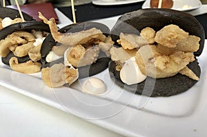 Creative fusion cuisine: Black version of asian baos with crispy spanish squid photo