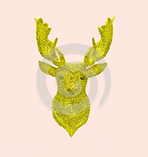 Creative golden fab Christmas reindeer made of glitter on pastel pink background. Winter concept New Year photo