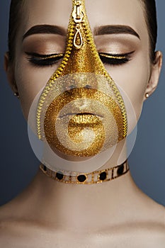 Creative grim makeup face of girl Golden color zipper clothing on skin. Fashion beauty creative cosmetics and skin care halloween