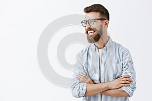 Creative happy and funny bearded man with moustache in glasses with black rim turning left laughing out loud enjoying