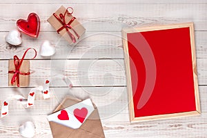 Creative happy valentine`s day card concept, gift box, red hearts, candle, envelope, flat lay, top view, nameplate with copy spac