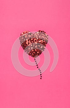 A creative heart made of small shiny hearts in the form of a balloon. The concept of Valentine`s Day